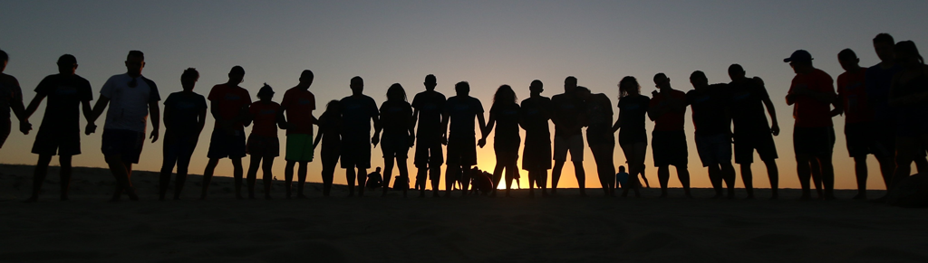 photo of people lined up on the horizon, silhouletted on the sunset